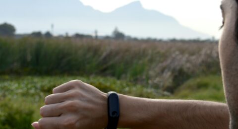 An adult exerciser reviewing a fitness tracker before a training session