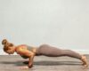 An adult yoga teacher demonstrating Chaturanga Dandasana on a mat