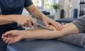 Therapist applying an instrument-assisted soft tissue technique during Graston therapy training