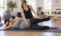 Pregnant participant practising supported prenatal Pilates with an instructor