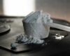 An unlabelled scoop of supplement powder on a dark surface, representing uncertainty about supplement contents.