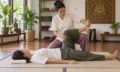 Thai massage therapist applying an assisted stretch