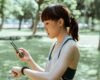 Adult runner checking a fitness tracker and smartphone after outdoor exercise