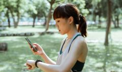 Adult runner checking a fitness tracker and smartphone after outdoor exercise