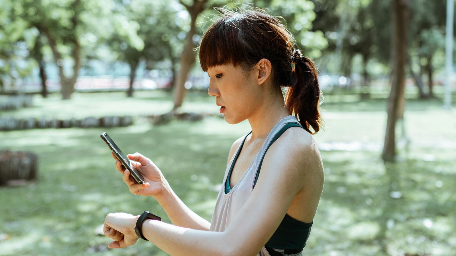 An adult exerciser checking a wrist-based heart-rate monitor during outdoor training