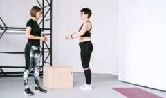 Older woman exercising beside a fitness instructor