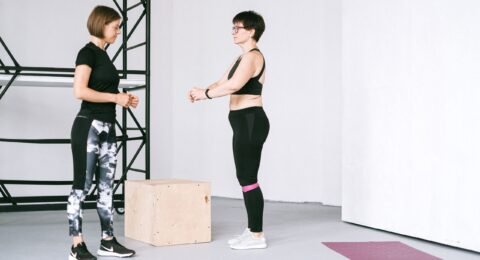 Older woman exercising beside a fitness instructor