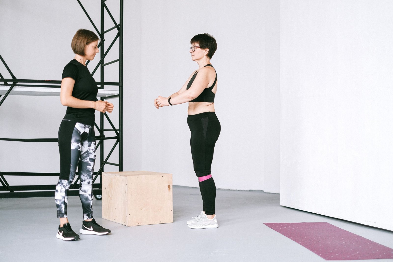 Older woman exercising beside a fitness instructor