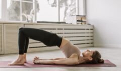 Adult performing a controlled bridge exercise on a mat