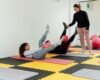 Adults exercising on mats in a bright studio