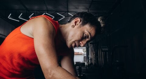 Sports massage practitioner working on an adult athlete’s leg after training