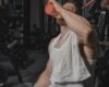 Exerciser wiping sweat with a towel and holding water after a workout