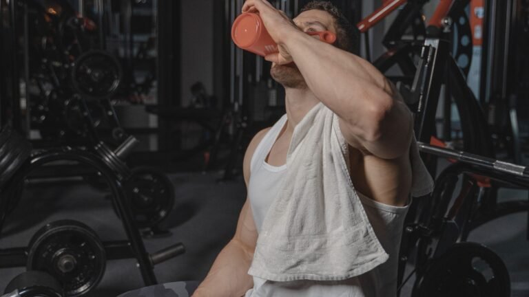 Exerciser wiping sweat with a towel and holding water after a workout